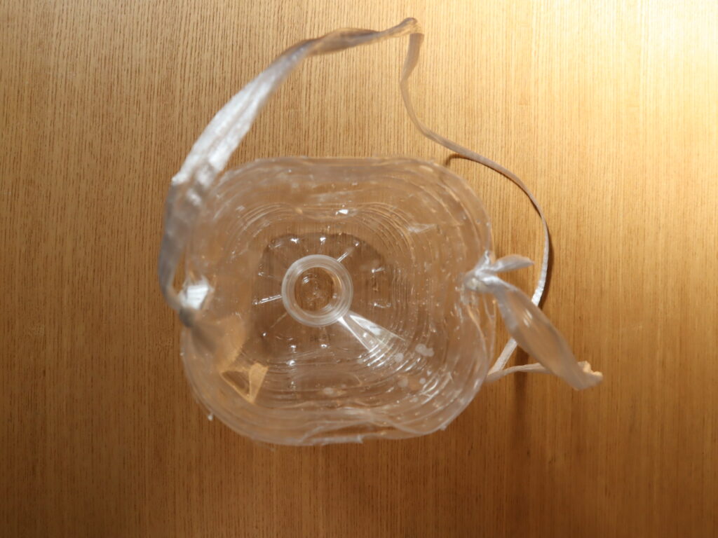 Photograph of a completed plastic bottle trap used for bottle fishing, showing the part of the trap that shows how the fish are caught.